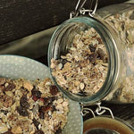 Bio-Müsli wird von Einmachglas in Schüssel umgefüllt